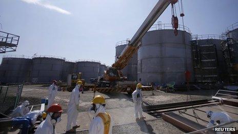 Workers wearing protective suits and masks are seen near tanks of radiation contaminated water at Tokyo Electric Power Company's (TEPCO) tsunami-crippled Fukushima Daiichi nuclear power plant in Fukushima prefecture March 6, 2013