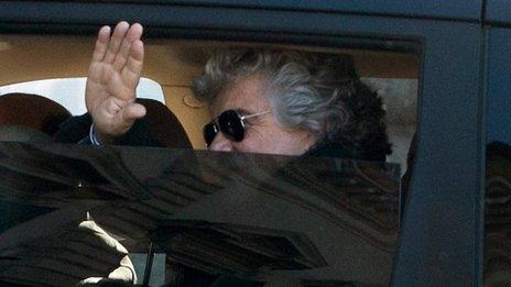 Five Star Movement leader Beppe Grillo waves from inside a car as he arrives for talks with Italian President Giorgio Napolitano on 21 March 2013