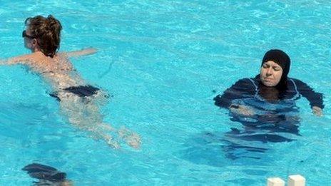 women swimming in tunisia - one in a bikini, the other covered up
