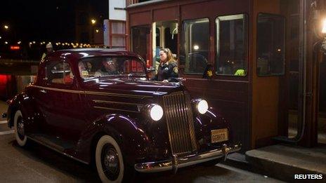 Collector Marilyn Alvardo receives the last toll from Jim Eddie in his vintage 1937 Packard, 26 March