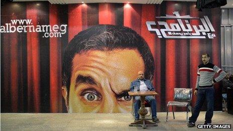 Egyptians gather in front of a poster of Egyptian satirist Bassem Youssef at a theatre in Cairo on January 22, 2013