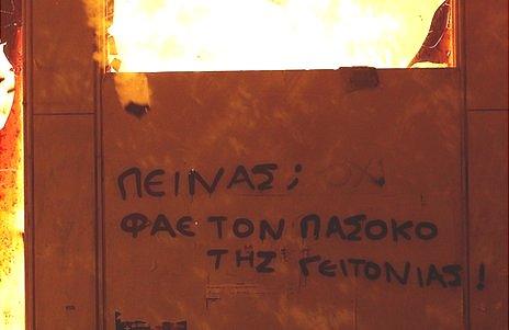 Anti-austerity, anti-Pasok graffiti on burning building