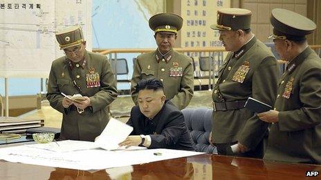 North Korean leader Kim Jong-un (seated) discusses strike plan with North Korean officers during a meeting at the Supreme Command in an undisclosed location (image released by state media on 29 March 2013)