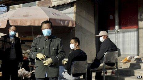 Chinese men stand guard in front of the house of a seven-year-old H7N9 bird flu patient in Gucheng village on the outskirts of Beijing