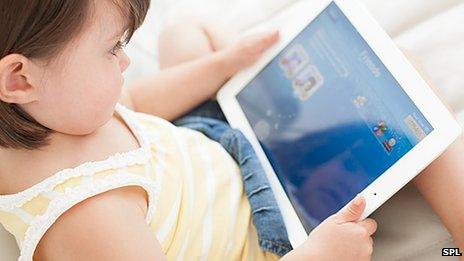 Young child playing with a tablet