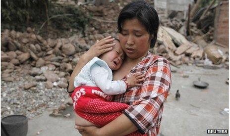 A woman comforts here baby in Longmen township, Sichuan (21 April 2013)