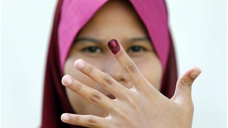 A Malaysian voter shows her ink-stained finger after casting her ballot during the early voting for the general elections in Kuala Lumpur, 30 April 2013