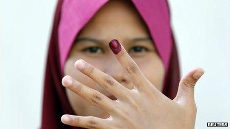 A Malaysian voter shows her ink-stained finger after casting her ballot during the early voting for the general elections in Kuala Lumpur, 30 April 2013