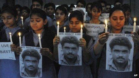 Indian school children hold photographs of Sarabjit Singh, an Indian spy on death row in Pakistan as they light candles and pray for his recovery in Amritsar, India, on 29 April 2013