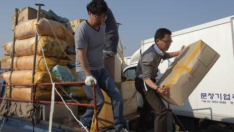 South Korean companies unload goods made in Kaesong across the border