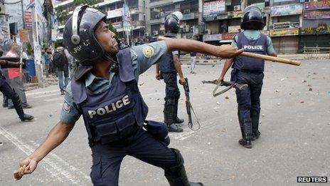A policeman throws a piece of brick during a clash with activists in Dhaka, 5 May 2013