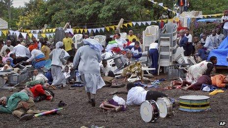 Wounded churchgoers lie on the ground as Catholic nuns run for cover after the blast in Arusha (5 May 2013)