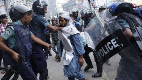 Police try to detain an activist during a clash in front of the national mosque in Dhaka, 5 May 2013