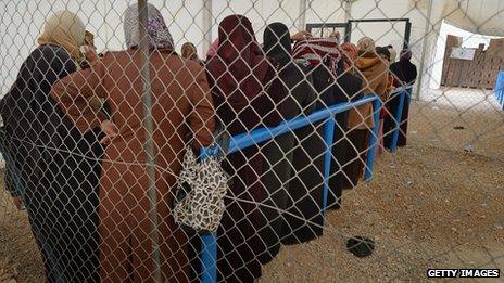 Syrian women collecting food and supplies from the UNHCR at Jordan's Zaatari refugee camp on 30 January 2013