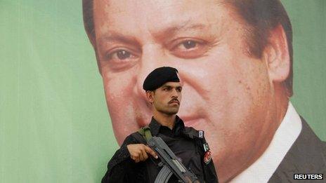 A paramilitary soldier guards in front of the portrait of Nawaz Sharif