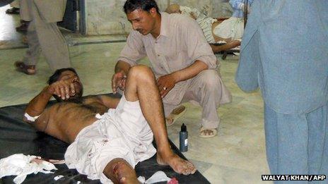 An injured Pakistani blast victim receives assistance at a hospital following bomb attacks in northwestern Malakand region (May 17, 2013)