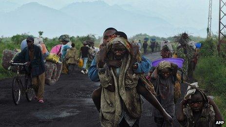 Congolese people carrying their children and belongings as they flee conflict (November 2013)