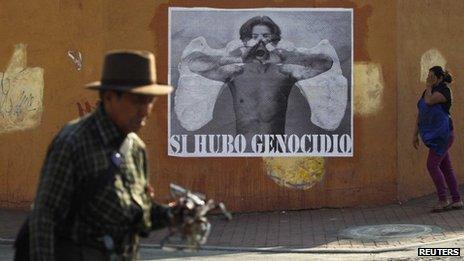 Guatemalans pass a poster reading: "Yes, there was a genocide" in Guatemala City on 15 May 2013