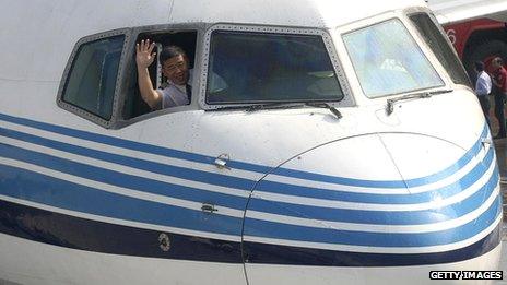 A pilot waves from the cockpit window at Songshan airport in Taipei, in 2008