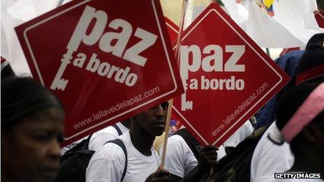 Colombians hold placards reading "Peace on board" at a peace march on 9 April 2013