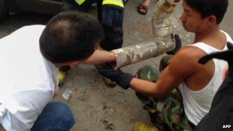 A rescue worker reaching into a pipe