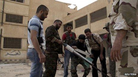 Free Syrian Army fighters prepare to launch a rocket in Deir al-Zor