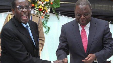 Zimbabwean President Robert Mugabe (L) shakes hands with Prime Minister Morgan Tsvangirai after he signed the new constitution into law at State house in Harare on Wednesday 22 May 2013