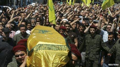 Hezbollah supporters carry the coffin of a militant killed fighting in Syria through the streets of Beirut (21 May 2013)