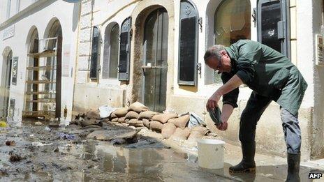 A resident cleans up his house in a street flooded by the river Danube in Passau, southern Germany, on June 5, 2013.