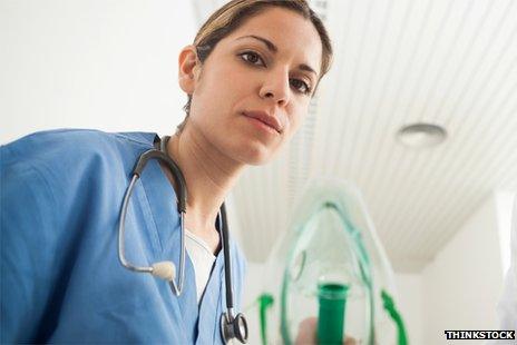 Generic image of a nurse leaning towards the camera, as though over a patient