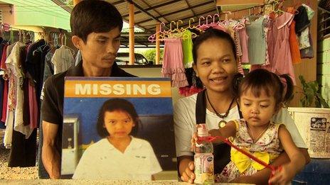 Kamol and Manee Thongchum with baby Om, and a missing persons poster to Jiji
