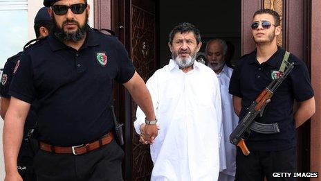 Former Libyan congress president Mohamed Balgassem al-Zway (C-back) and former Libyan foreign affairs minister Abdelati Obeidi (C) are escorted by police following a hearing in their trial on May 6, 2013 in the capital Tripoli.
