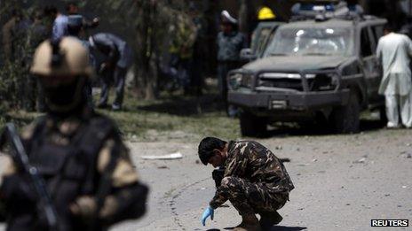 Afghan security forces personnel investigate the site of the explosion in Kabul on 18 June 2013