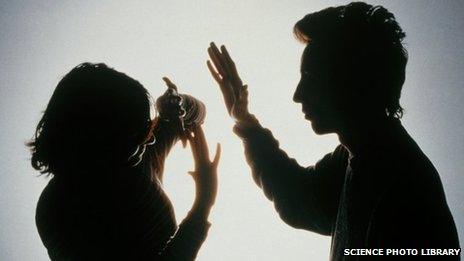 Silhouette of a woman protecting herself from a blow from her partner
