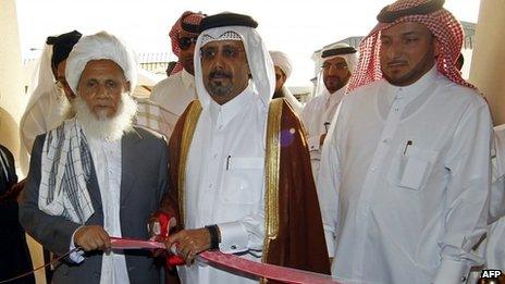 Qatari Assistant Minister for Foreign Affairs Ali bin Fahd al-Hajri (C) cuts the ribbon alongside a member of the Taliban"s office Jan Mohammad Madani (L) at the opening ceremony of the new Taliban political office in Doha