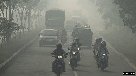Motorists travel through haze in Pekanbaru, Indonesia's Riau province on 20 June 2013