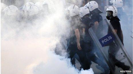 Police walk amidst tear gas during protests at Kizilay square in central Ankara, June 16, 2013