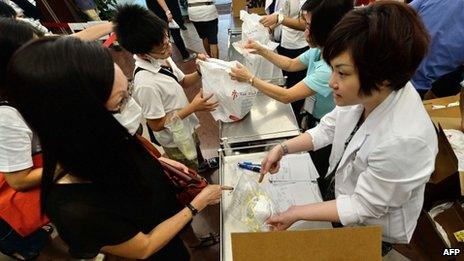 People queue to buy face masks at a hospital in Singapore on 21 June 2013