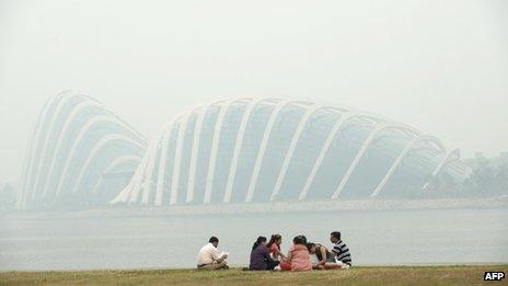 A group of people sit opposite the Garden by the Bay in Singapore on 20 June 2013