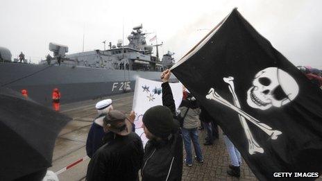 Relatives wave a pirate flag as a frigate returns from anti-piracy mission Somalia in 2009