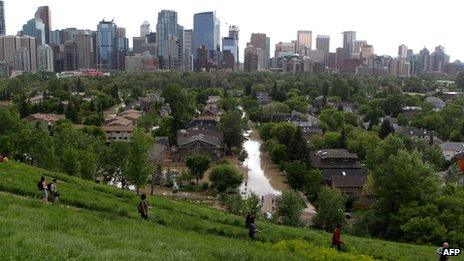 Residents take a higher ground to watch the flood situation near the flooded Bow River in Calgary, Alberta, 22 June 2013