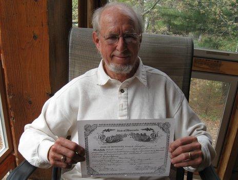 Pastor Roger Lynn holds up the marriage certificate of Michael McConnell and Jack Baker