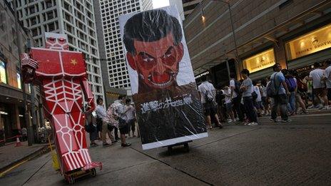 A defaced picture of of Hong Kong"s Chief Executive Leung Chun-ying is displayed in a downtown street during an annual pro-democracy protest in Hong Kong Monday, July 1, 2013