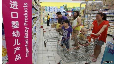 A family looks at imported milk powder products at a supermarket in Beijing, 3 July 2013