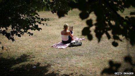 A woman reading in the sun, St James' Park, London