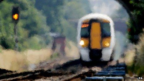 An approaching train looks blurred through the heat haze
