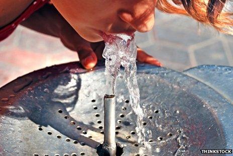 Someone drinking from a water fountain