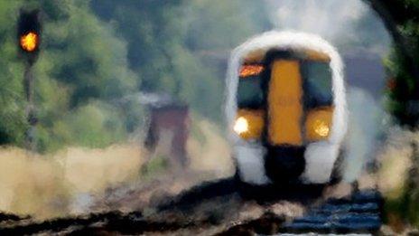 An approaching train looks blurred through the heat haze