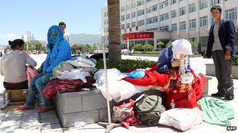 People wait outside the Minxian county hospital for treatment after an earthquake hit the area in Minxian county of Dingxi, northwest China's Gansu province on 22 July 2013