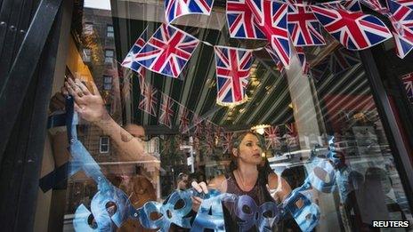 Employees hang a sign celebrating the royal birth in the window of the British-themed restaurant in New York on 22 July 2013